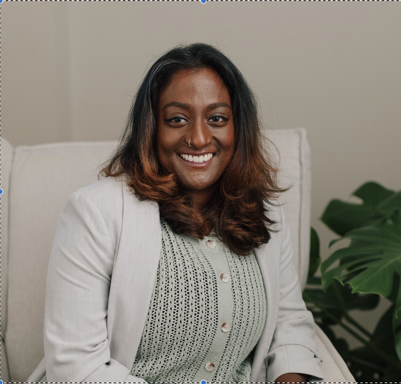 Malar Chandran, a Queer BIPOC Therapist sitting in her therapy office at Haven Wellness Collective in Vancouver