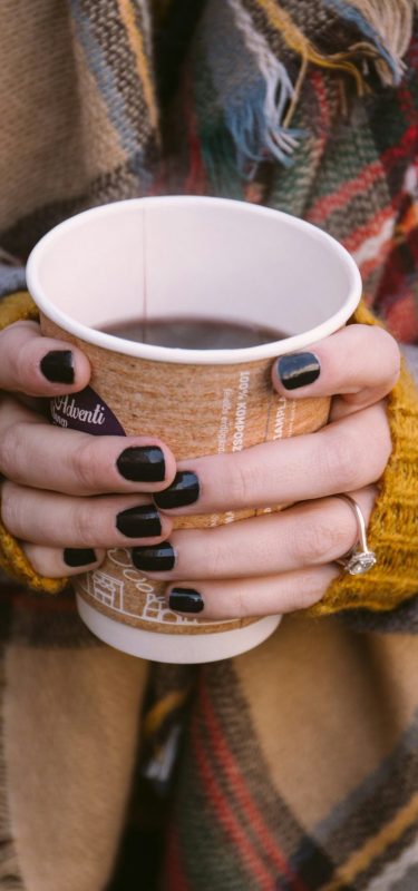 woman holds a warm drink in the winter to support her seasonal depression