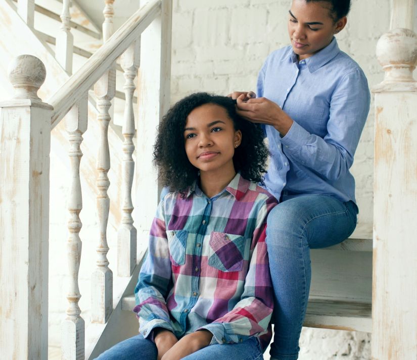 counselling for parenting a teenager can help you connect with your teen as a mom braids her daughters hair